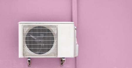 air compressor hanging on pink wallの写真素材