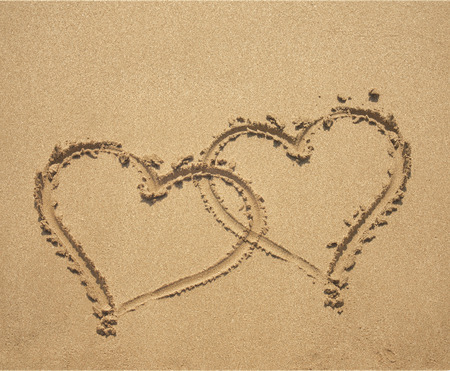 two hearts symbol on sandy beach backgroundの写真素材