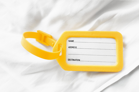 luggage tag label on white bedの写真素材