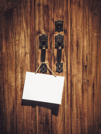 white blank sign board hanging on wooden vintage doorの写真素材