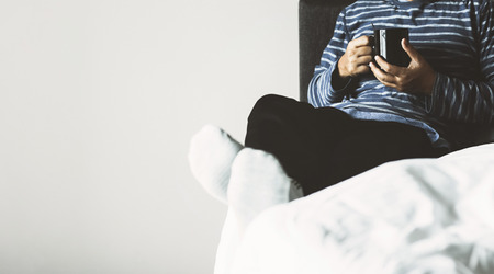 a man in morning bedroom with coffee cupの写真素材