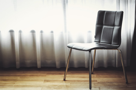 black leather chair with white curtain backgroundの写真素材