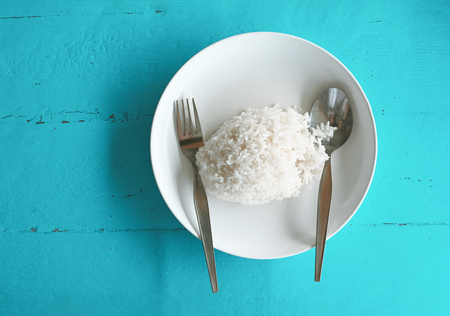 rice on white plate with blue wooden backgroundの写真素材