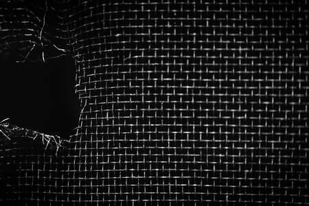 hole in window screen black and whiteの写真素材