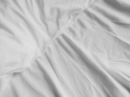 messy white bed sheets backgroundの写真素材