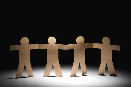 unity of paper human team in the dark backgroundの写真素材