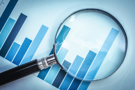 magnifying glass focus on business financial graph in blue toneの写真素材