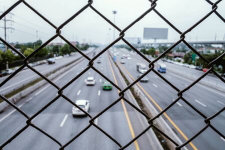 wire mesh fence with blur motorway backgroundの写真素材