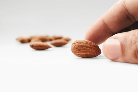 hand pick roasted almond on white background