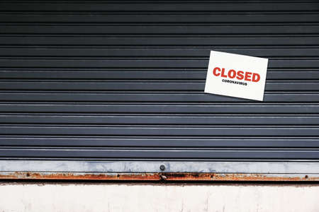 street store close or lease amid the coronavirus pandemic. small shops had to close due to the economic crisis and lack of tourists. a closed sign on the old metallic roller shutter door.の写真素材