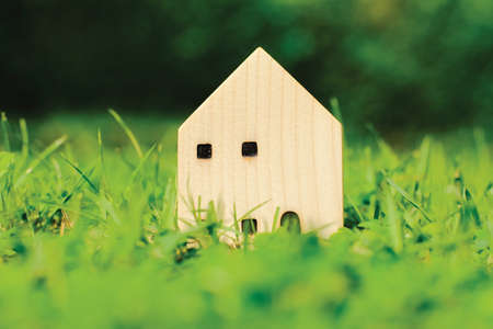 model house on green grass with blurred background. ideas about buying, selling, or renting a home. natural environment with habitat.の写真素材