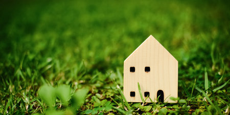model house on green grass with blurred background. ideas about buying, selling, or renting a home. natural environment with habitat.の写真素材