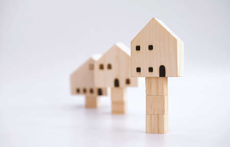 Property value and asset concept. Residential price growth. Investment in the real estate market. Home appraisals cost. House valuation. Wooden models with stacks of the block on white background.の写真素材