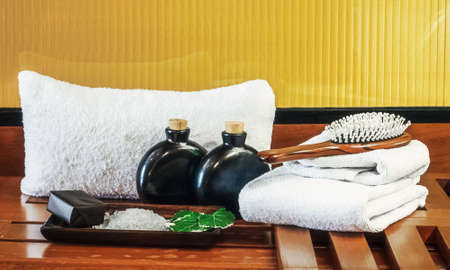 spa setting with body care items. white towels with natural soap and salt for bathing. aromatherapy healthcare products. relaxation and wellness concept. bath accessories.の写真素材