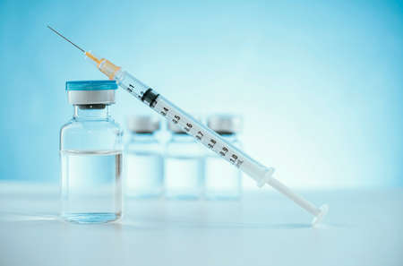 Vaccine manufacturers.  Vaccine bottles with a syringe for injection. Immunization and treatment. Medicine vial. Healthcare and medical development concept.の写真素材