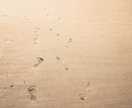 Footprint background. Barefoot walking on the smooth sandy beach.