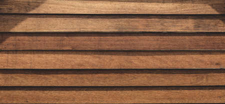 Planks on the wall. Wood panel background. Brown wooden texture surface. Hardwood board backdrop.の写真素材