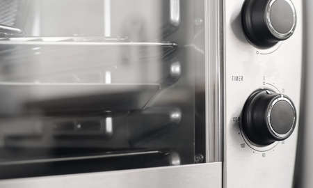 Home appliance in the kitchen. Cooking or baking with the oven. Close up analog timer. Round knob control dial.の写真素材