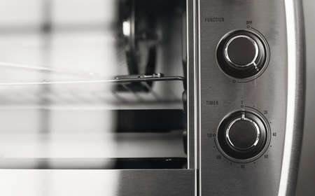 Home appliance in the kitchen. Cooking or baking with the oven. Close up analog timer. Round knob control dial panel.の写真素材