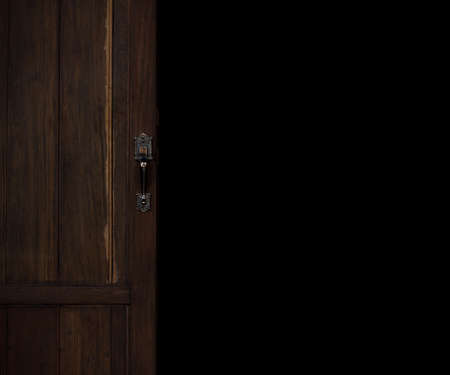 Wooden door is opening and black backdrop for copy space. A large vintage door that looks luxurious and classic. The historical background. Gate doorway.の写真素材