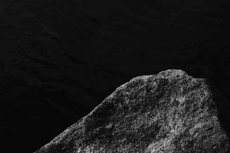 The rock shelf above the sea. Gray stone backdrop with black copy space. Rough texture boulder...