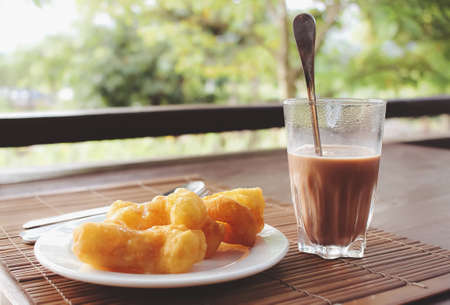 Morning breakfast on the table. Chinese donut or chinese bread stick with a cup of hot chocolate milk. Deep-fried strip of dough (Pathongko).の写真素材