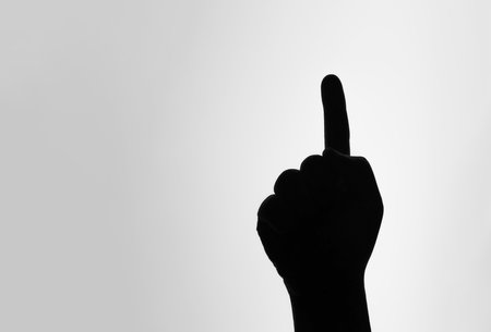 Believe in one God. One finger symbol. The silhouette of raising hand sign and pointing above.の写真素材