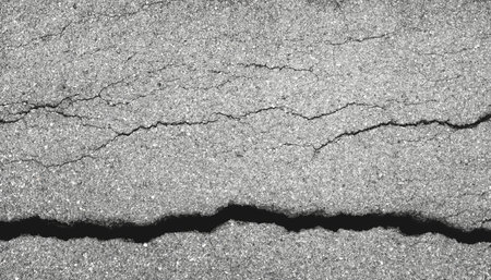 Earthquake disaster background. Cracks of road surface. Broken concrete backdrop. Asphalt pavement damage.の写真素材