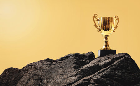 Golden trophy cup on the top of the rock mountain. Business goal and success concept. Champion reward. Prize to winner. Challenge for victory.の写真素材