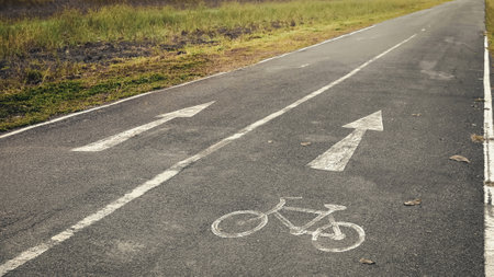 Natural cycling path. Bicycle sign on tarmac road. Morning exercise and recreation. Bike lane in the park.の写真素材