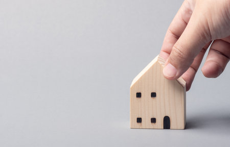 Hand picking a model house with copy space background. Housing selection. Real estate transaction. House agent. Home renovation and maintenance concept.の写真素材
