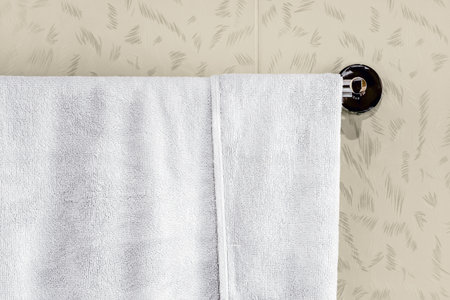 White towels hang on the rail in the bathroom for shower.の写真素材