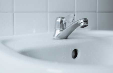 Old tap on white basin. Clean and hygeiene concept.の写真素材
