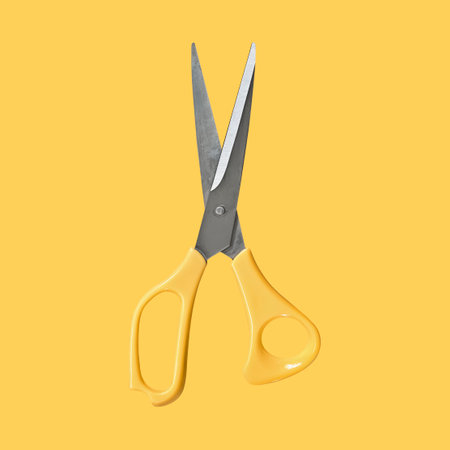 Yellow scissors on yellow backdropの写真素材