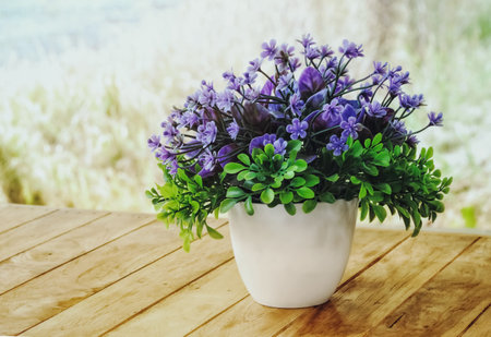 Still life of bouquet of flowers in the vase on wooden table. Spring summer season. Purple and green flora.の写真素材
