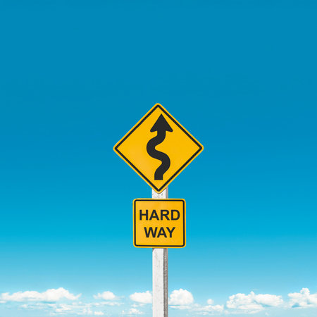 Obstacles await on the path ahead. Traffic sign warning winding curves against sky background. Striving in hard way for success. Challenging difficulty. Self-improvement motivation. Test of life.の写真素材