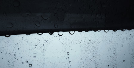 Raindrops on the edge of the car glass background. Water on the window glass.の写真素材