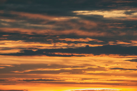 Dramatic sunset sky. Warm cloudscape background. Twilight sunlight.の写真素材