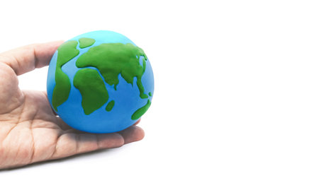 Globe model in hand with copy space on white background. Sustainability and Preservation. World environmental concept. Save the planet earth.の写真素材
