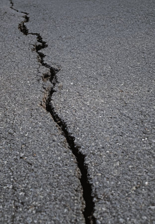 Earthquake disaster background. Cracks of road surface. Broken tarmac backdrop. Asphalt pavement damage.の写真素材