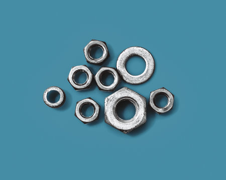 Group of metal nut on blue background. Construction equipment and DIY work.