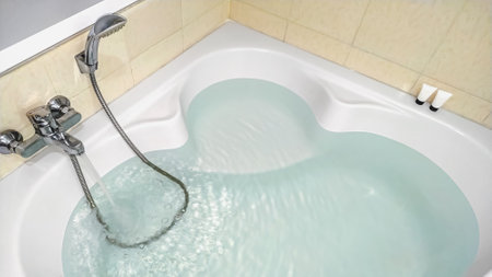 Water flow from faucet to bathtub. Hot and cold water taps for relaxing and soaking in the bathroom....