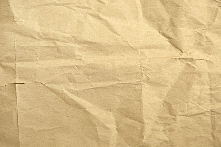 Crumpled brown paper texture for use as a natural background, eco-friendly packaging concept, or vintage style design element.の写真素材