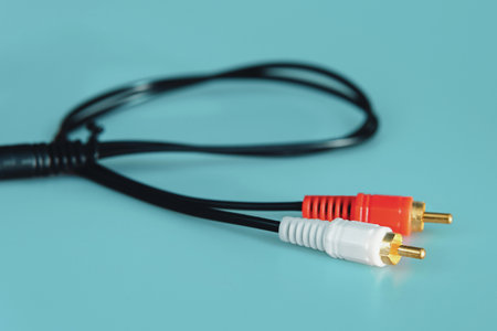 Close-up shot of an RCA audio cable with red and white connectors, a common accessory for connecting sound and video devices.の写真素材