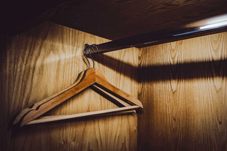 Wooden hanger in the closet in warm toneの写真素材