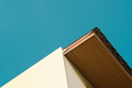 Old wooden eaves roof and walls of the house contrast with bright blue sky. Perfect for articles...
