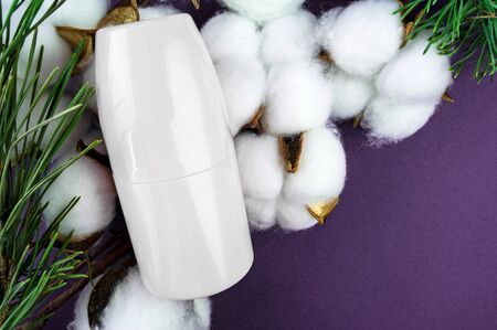 Mockup antiperspirant on a purple background. Cotton and fir branches - natural eco cosmetics.の写真素材