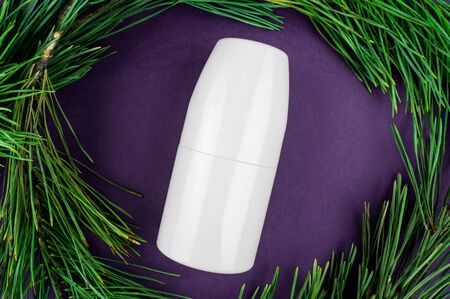 Mockup antiperspirant on a purple background. Fir branches - natural eco cosmetics.の写真素材