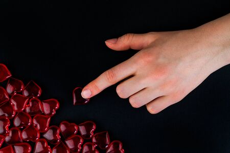 The hand complements the missing element of love on black backgroundの写真素材