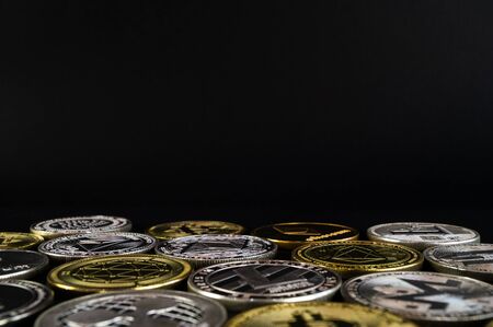 A lot of cryptocurrency coins lie on a dark surface backgroundの写真素材